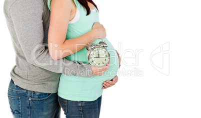 loving future parents holding a clock