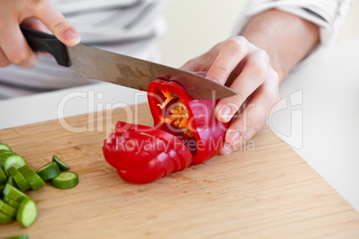 close-up of a man cutting red pepper