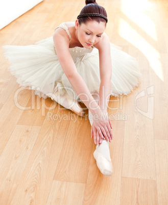 Beautiful dancer stretching on the floor