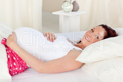 mother in pyjamas lying on her bed