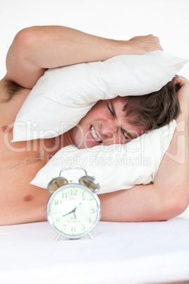 angry man woken up by his alarm clock