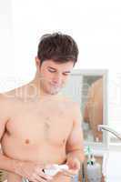 man putting shaving-foam standing in his bathroom