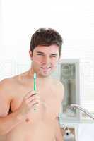 man holding his toothbrush in the bathroom