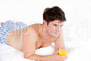 boy in pyjamas holding a glass of orange juice