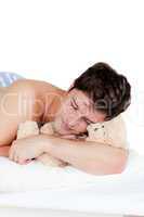 man in pyjamas sleeping with a teddy-bear
