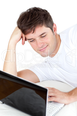 man using his laptop lying on the ground