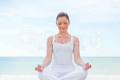 woman doing yoga on beach