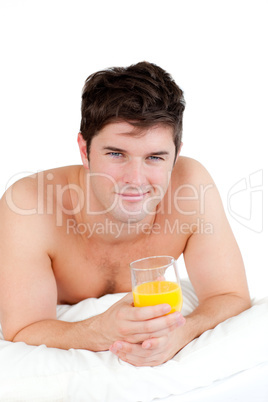 man lying on his bed with a glass of orange juice