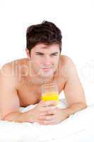 man lying on his bed with a glass of orange juice