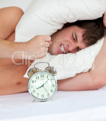 angry man stressed by his alarm clock