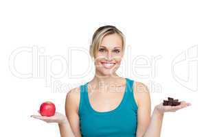 woman comparing apple with chocolates