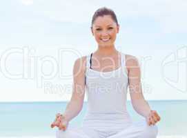 woman doing yoga over sea background