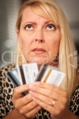 Upset Woman Glaring At Her Many Credit Cards