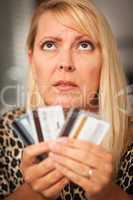 Upset Woman Glaring At Her Many Credit Cards