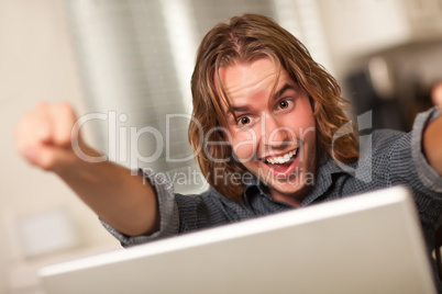 Cheering Young Man Using Laptop Computer