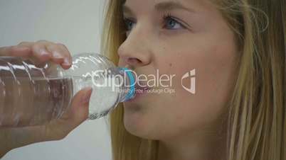 HD1080p25 Young woman with water bottle in hand against white background