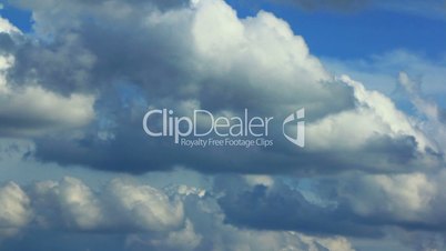 White fluffy clouds over blue sky. Time-lapse