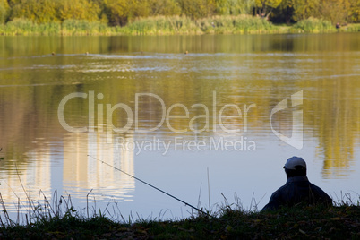 fisherman silhouette near pond