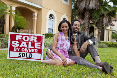 Happy African American Couple Beside House For Sale Sold Sign