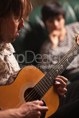 Young Musician Plays His Acoustic Guitar as Friend Listens