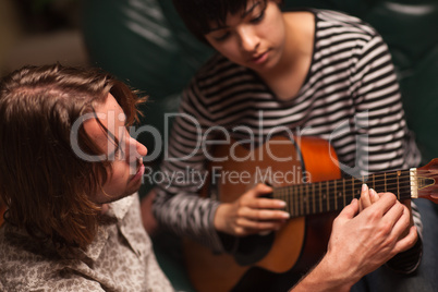 Young Musician Teaches Female Student To Play the Guitar