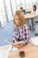 Happy female student with book in classroom