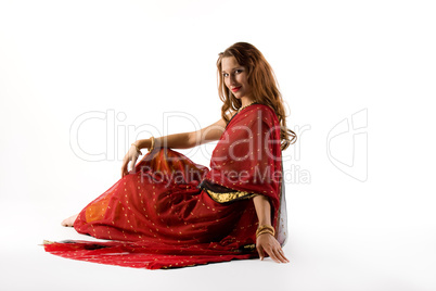 Young woman in traditional dress sit on white