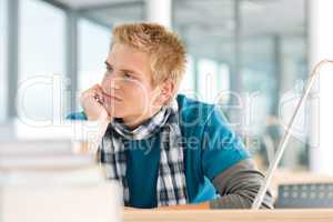 Portrait of thoughtful male student with books