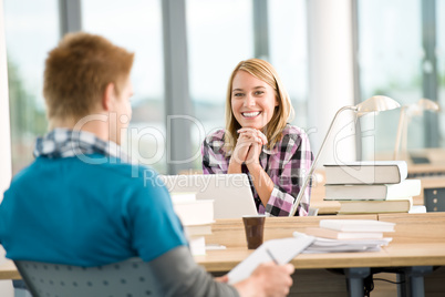 Two students with books and laptop