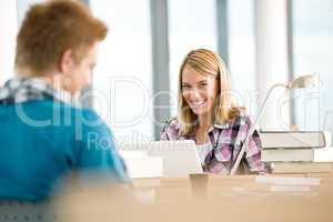 Two students with books and laptop