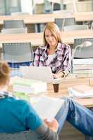 Two students with books and laptop