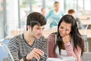 Two students read book in classroom