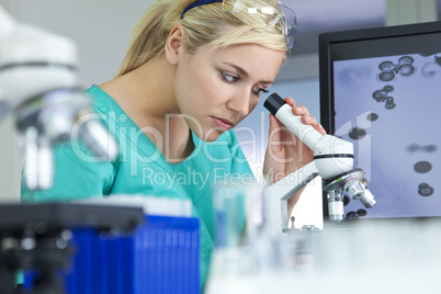 Female Scientist or Woman Doctor Using Microscope in Laboratory