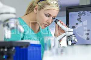 Female Scientist or Woman Doctor Using Microscope in Laboratory