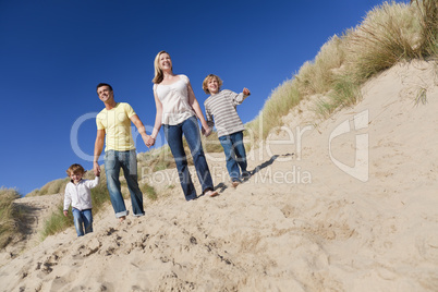 Mother, Father and Two Boys Walking Having Fun At Beach