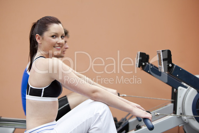people using a rower in a fitness centre