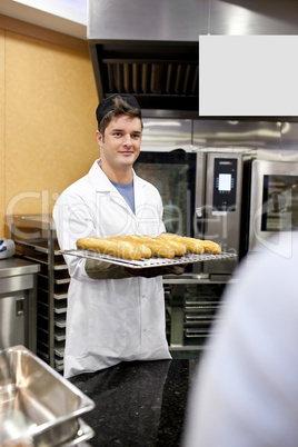 baker holding baguettes and breads