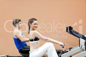 people using a rower in a sport centre