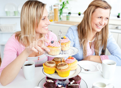 Women eating cupcakes in the kitchen
