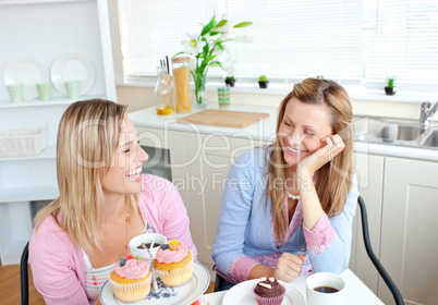 women eating cupcakes and drinking coffee