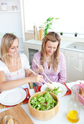 women eating salad in the kitchen