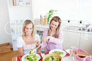 woman serving salad to her friend