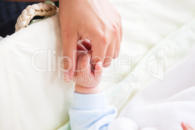 mother holding the hand of her baby
