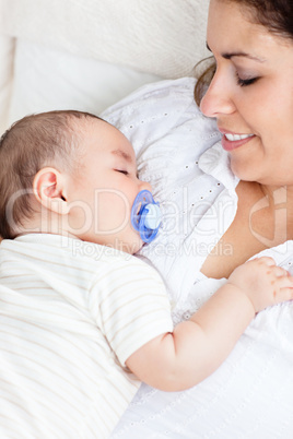 cute baby sleeping peacefully in his mother's arms