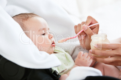 mother giving mashed potatoes to her baby