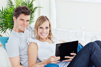 couple lying on the sofa with laptop