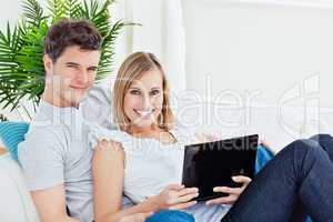 couple lying on the sofa with laptop