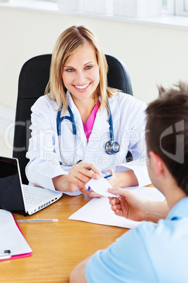 doctor giving a prescription to her male patient