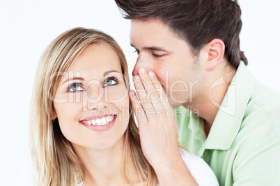 man whispering something to his female friend