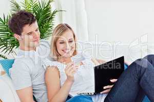 couple with laptop resting on the sofa
